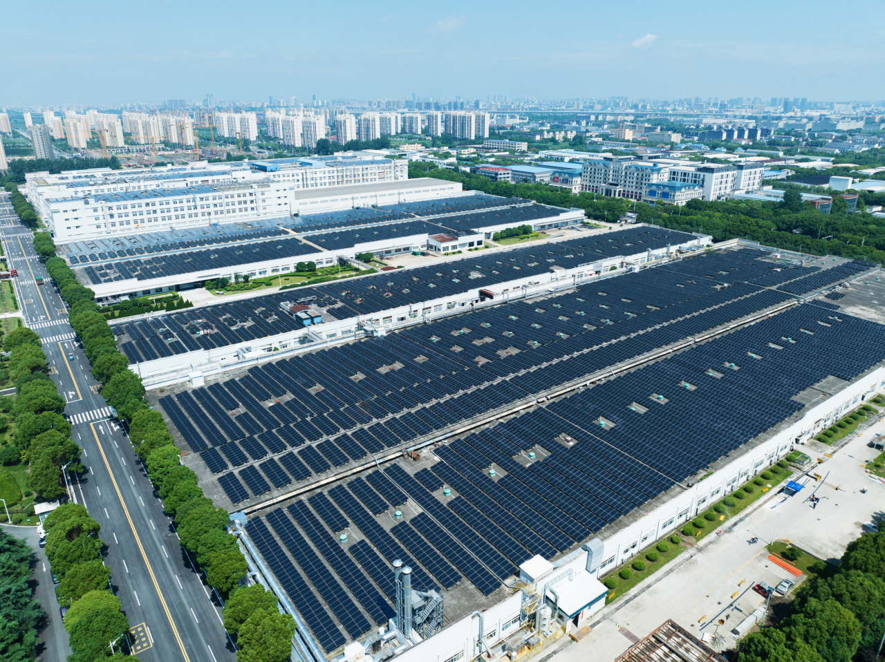 Aerial view of modern storage warehouse with solar panels on the roof. Logistics center in industrial city zone from drone view. Background texture concept.
